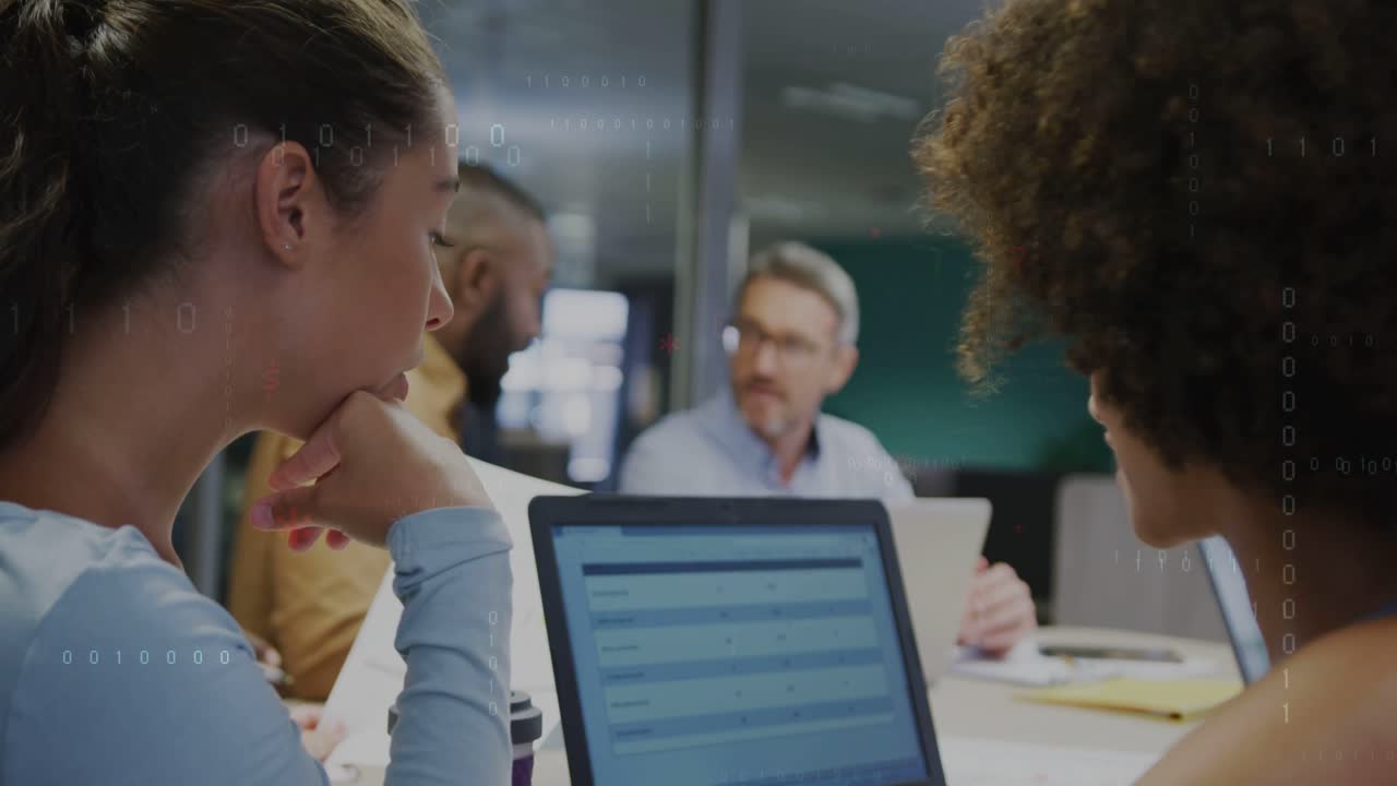 Left woman tapping laptop after right woman pointing rows, HUD flagging table data for business
