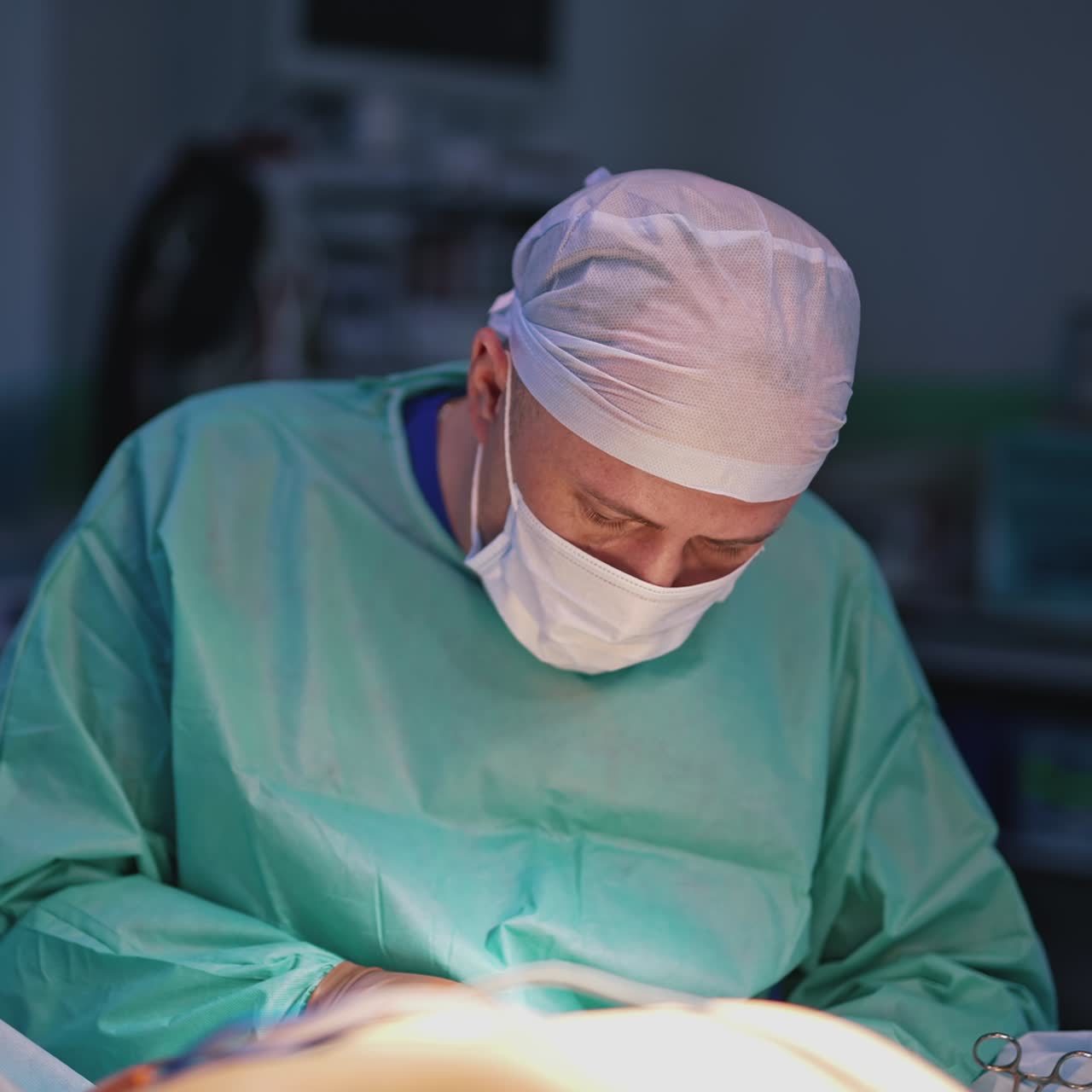 Confident doctor near operating table. Portrait of a professional surgeon in medical mask and uniform performing a plastic surgery