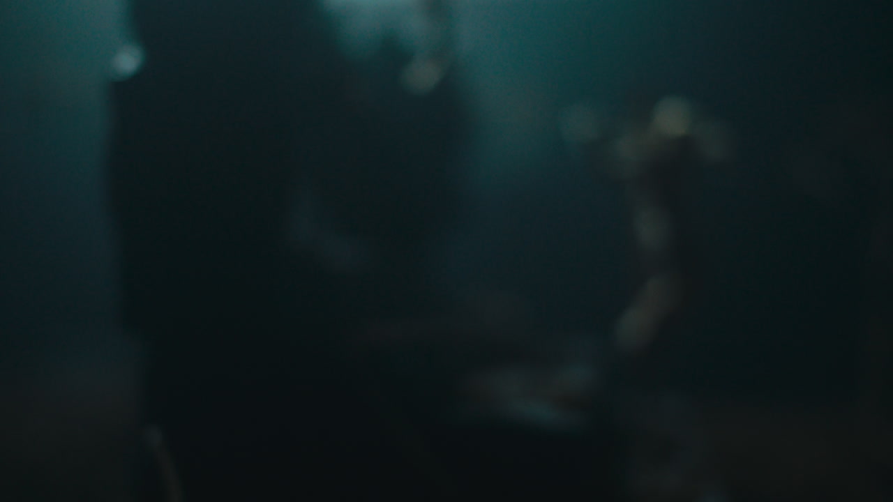 A miniature mummified doll hanging on the gallows at night