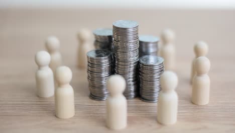 wooden figures surrounding stacks of coins