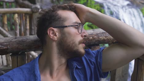 un joven adicto frustrado fumando un cigarrillo al aire libre.