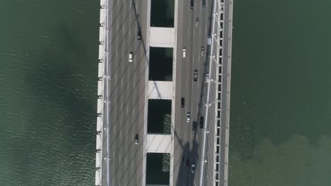 Aerial-shot-of-vehicles-moving-on-San-Francisco–Oakland-Bay-Bridge-with-city-in-background