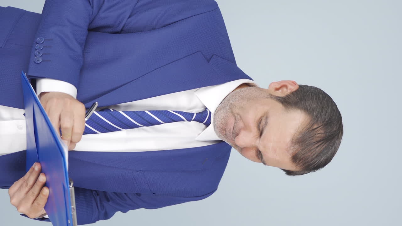 화난 사업가가 카메라를 바라보는 수직 비디오.