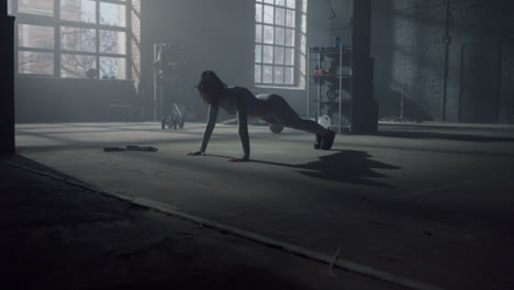 Woman-having-sport-challenge-in-gym.-Female-athlete-making-push-ups-on-floor