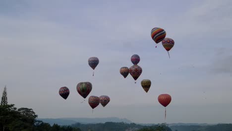 aerial drone view of colorful hot air balloon flying with cloudy sky on the background