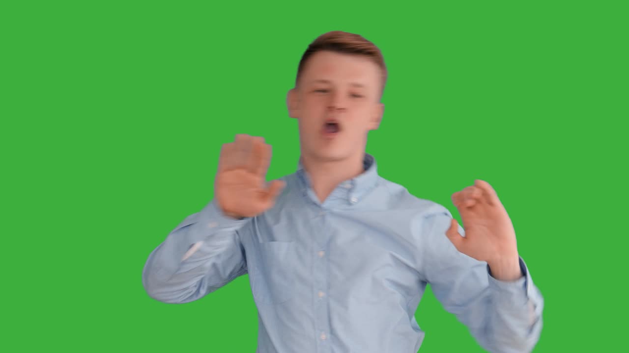 joven caucásico de pie contra el fondo de la pantalla verde. persona masculina aislada en la llave de croma. retrato profesional de negocios casual