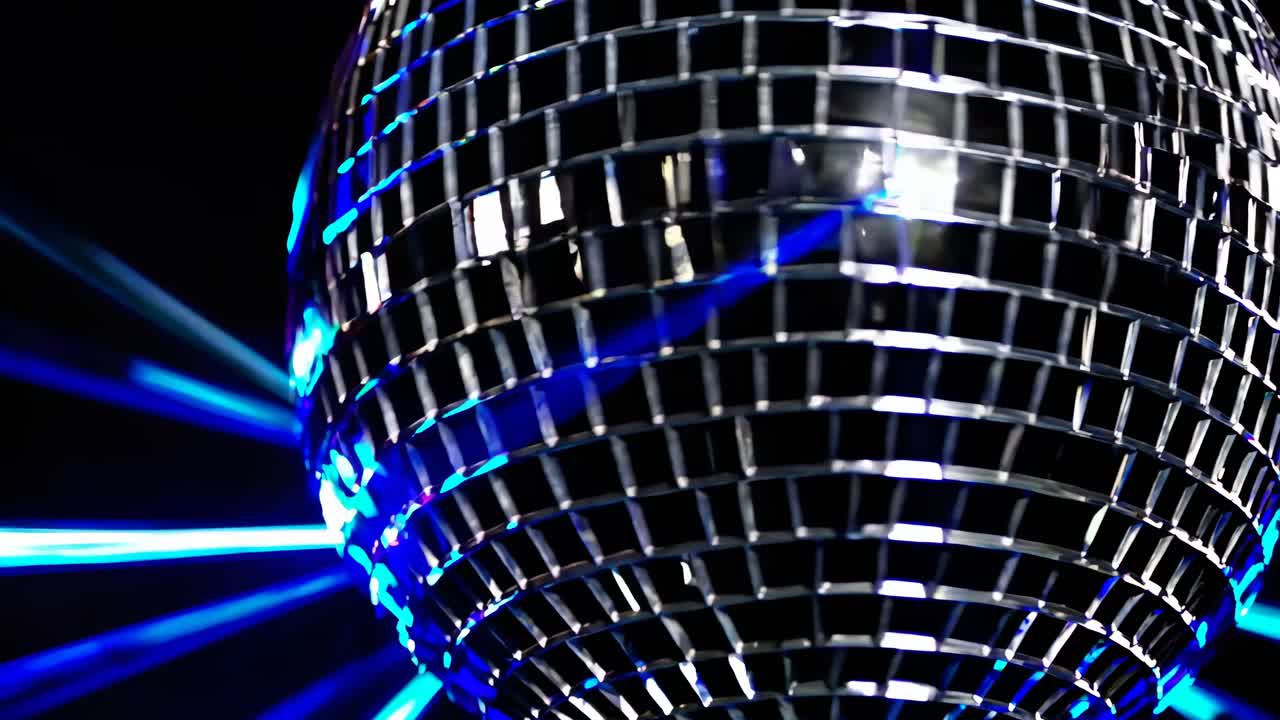 Primo piano, angolazione dal basso di una sfera da discoteca riflettente con luci blu, per creare un’atmosfera vivace ed energica