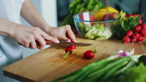 mujer con cuchillo cortando rábanos para ensalada