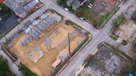 drone view that reveals electricity station surrounding by homes in neighborhood
