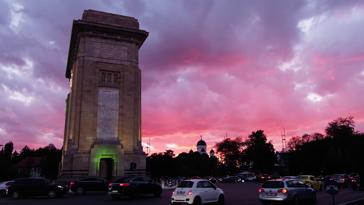 Bucharest, Romania - April 24, 2021: Cars moving near The Triumphal Arch at sunset. Vertical