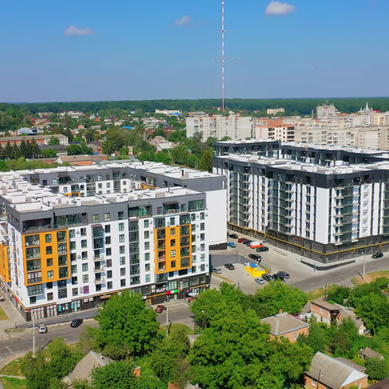 Modern residential complex in the city. Newly built apartment buildings in sunny daytime. Exterior of new urban infrastructure. Aerial view. Motion camera back.