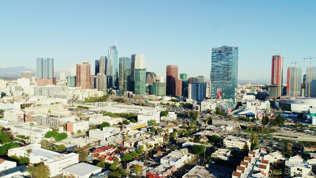Golden hour illuminates Los Angeles skyline with warm glow over city buildings