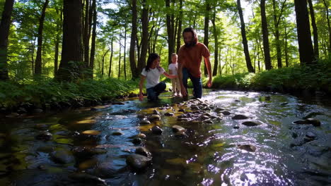 family hiking in the forest creek