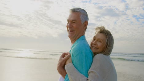 Active-senior-Caucasian-couple-embracing-each-other-on-the-beach-4k