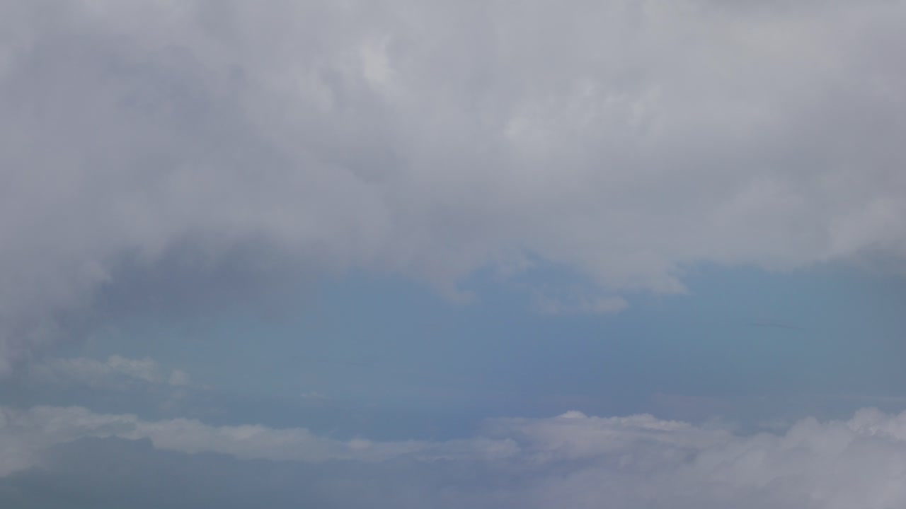 View of large clouds above and below outside of chromatic airplane window, Santorini, Greece, Europe