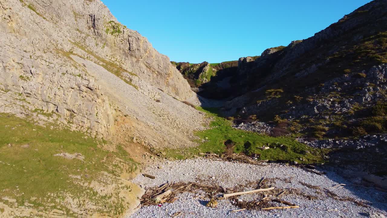 Hurtig flyvning ind i lille klippefyldt dal på en klar dag. Rejse Natur Drone Klip. Smukke walisiske Gower Peninsula kyst