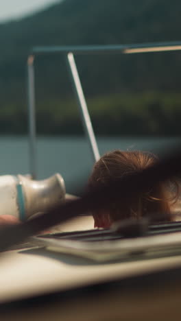 active little girl with back brace goes down to motorboat cabin sailing tranquil sea. child travels by comfortable yacht at oceanside on summer holiday