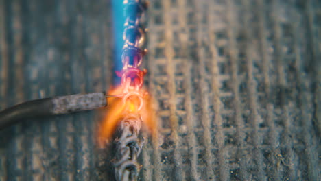 welding of golden chain with needle and gas burner closeup