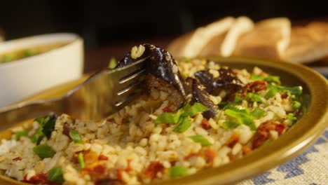 eating greenery on bulgur with eggplant close-up. traditional middle eastern culture. delicious rice with meat. arabian cuisine. homemade food concept