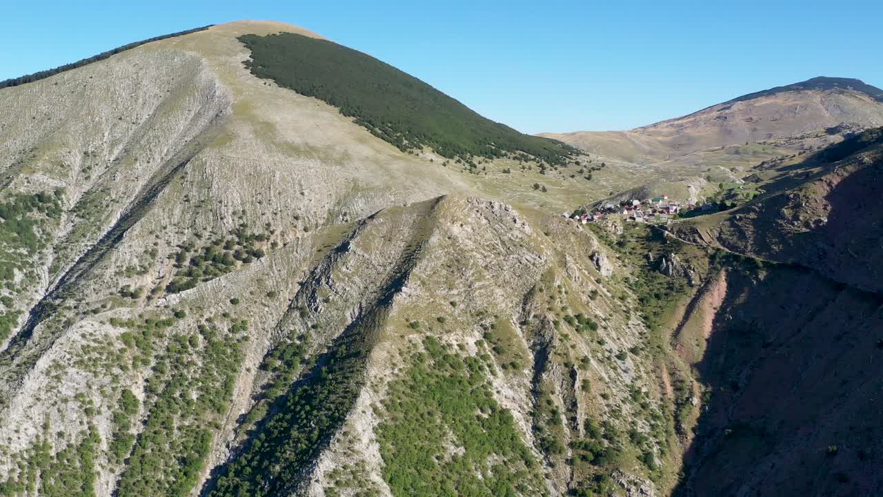 High aerial approaching long range view of quaint small village on mountaintop, Bosnia