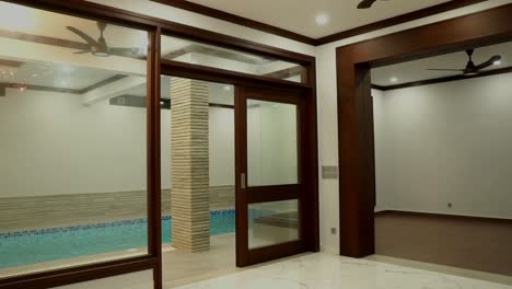 view from empty room looking through to indoor swimming pool