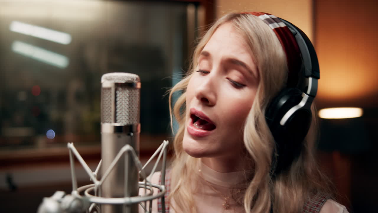 A woman singing in a recording studio
