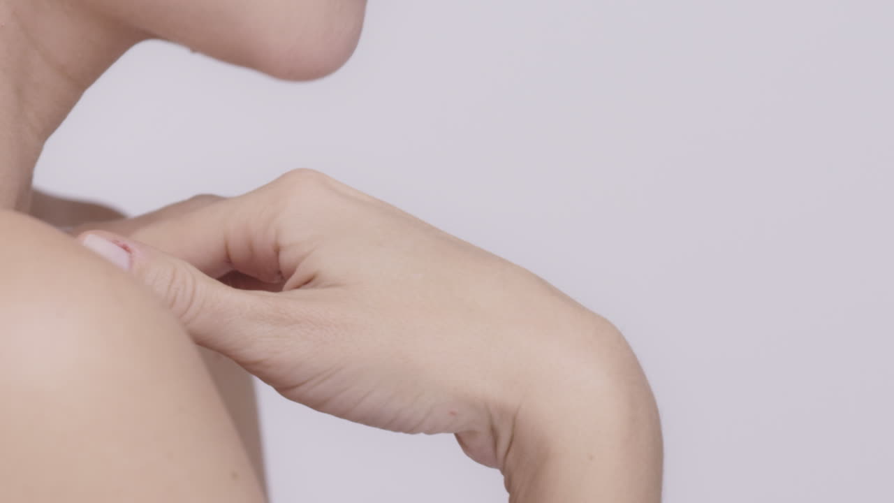 아름다운 건강한 여성이 목을 만지며 슬로우 모션으로 피부를 만지고 있습니다. 회색 바탕에 있는 미용 피부 관리 개념 빨간 서사시 드래곤