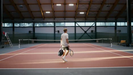 man playing tennis in an indoor court