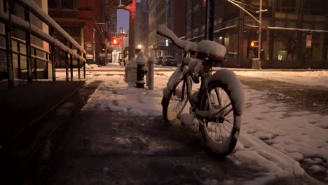 snow covered bicycle in soho , manhattan during snowy morning before sunrise