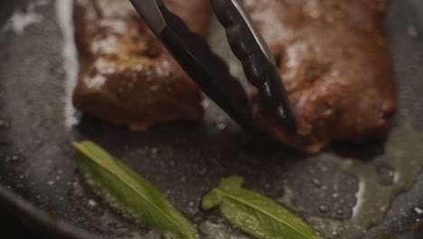 unrecognizable cook frying roasted meat in pan