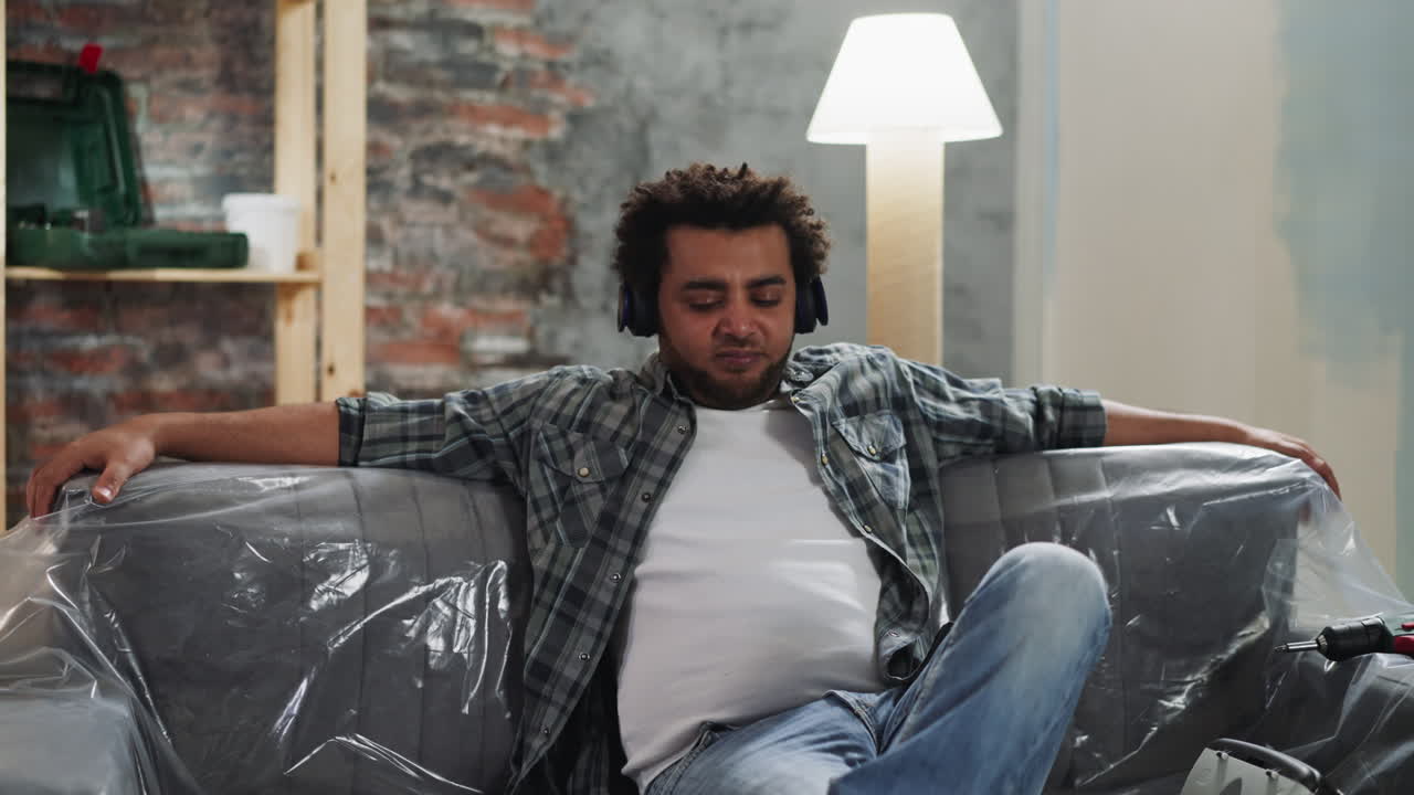 Black guy with earphones plays imaginative instrument