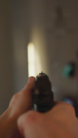 vista en primera persona de una persona moviéndose cautelosamente por un pasillo con una pistola, filmada con una cámara de mano