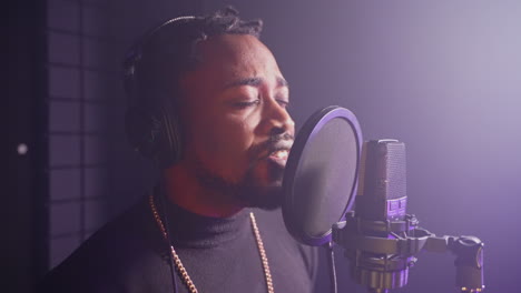 man singing into a microphone in recording studio