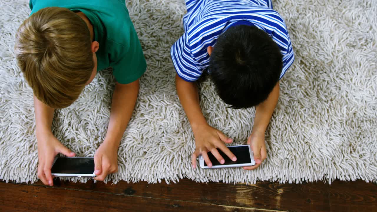 hermanos usando teléfonos móviles en la sala de estar