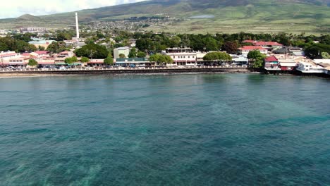 drone far away pan across front street in lahaina maui along the blue ocean coast