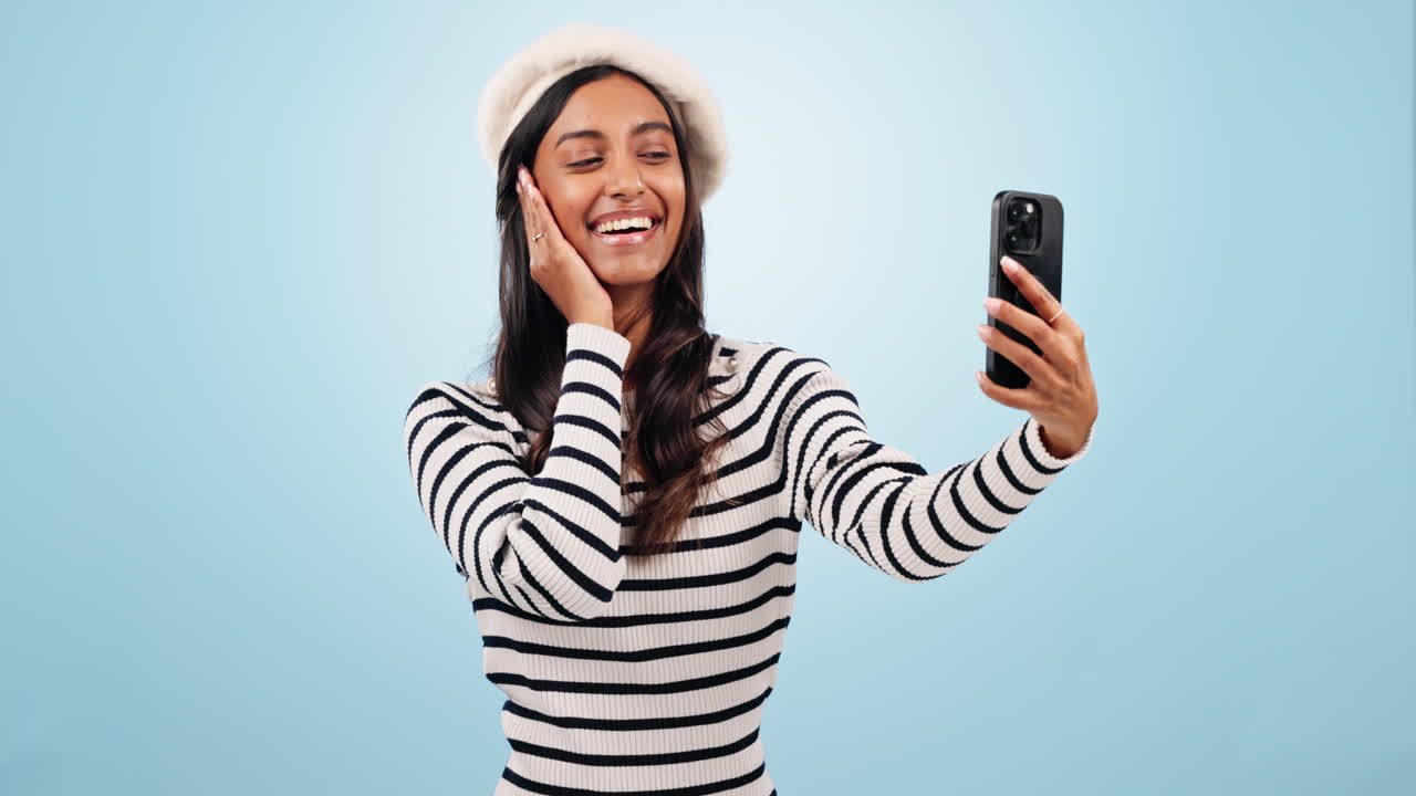 Cellulare, selfie e giovane donna in uno studio