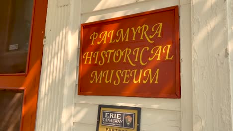 slow push in on the sign of the museum near downtown palmyra new york