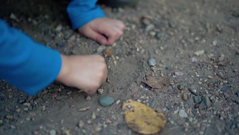 boy makes a picture of the stones on the road