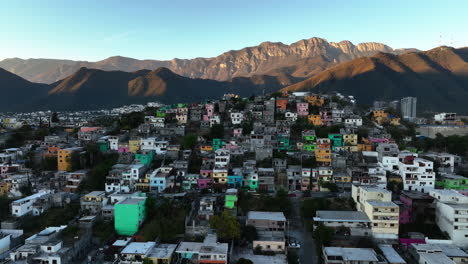vista aérea de la colorida casa de la favela en la ladera de una colina en monterrey, puesta de sol en méxico - descendente, disparo de drones
