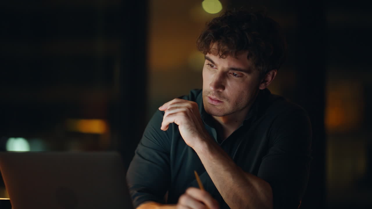 Freelancer working late evening drinking coffee at dark workspace closeup