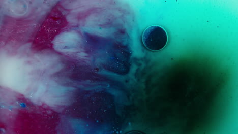 colorful ink clouding in water creating an abstract art effect, with vibrant turquoise and magenta hues merging