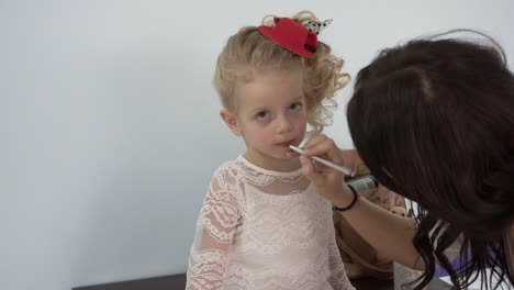 niña pequeña haciendo su maquillaje.