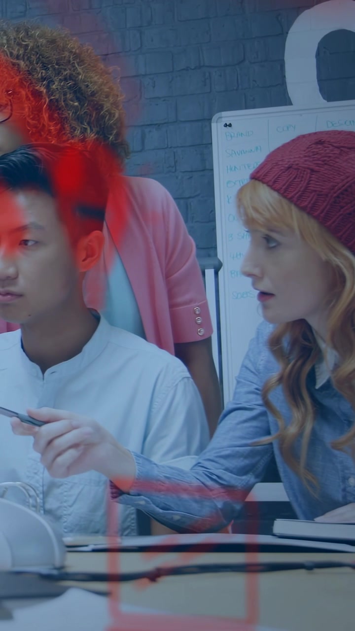 Vertical video: Red mark showing on glass urging beanie woman pointing pen at notes editing design