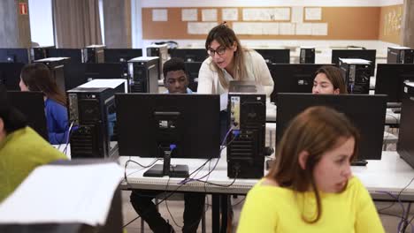 Young multiracial students using computer inside classroom at school