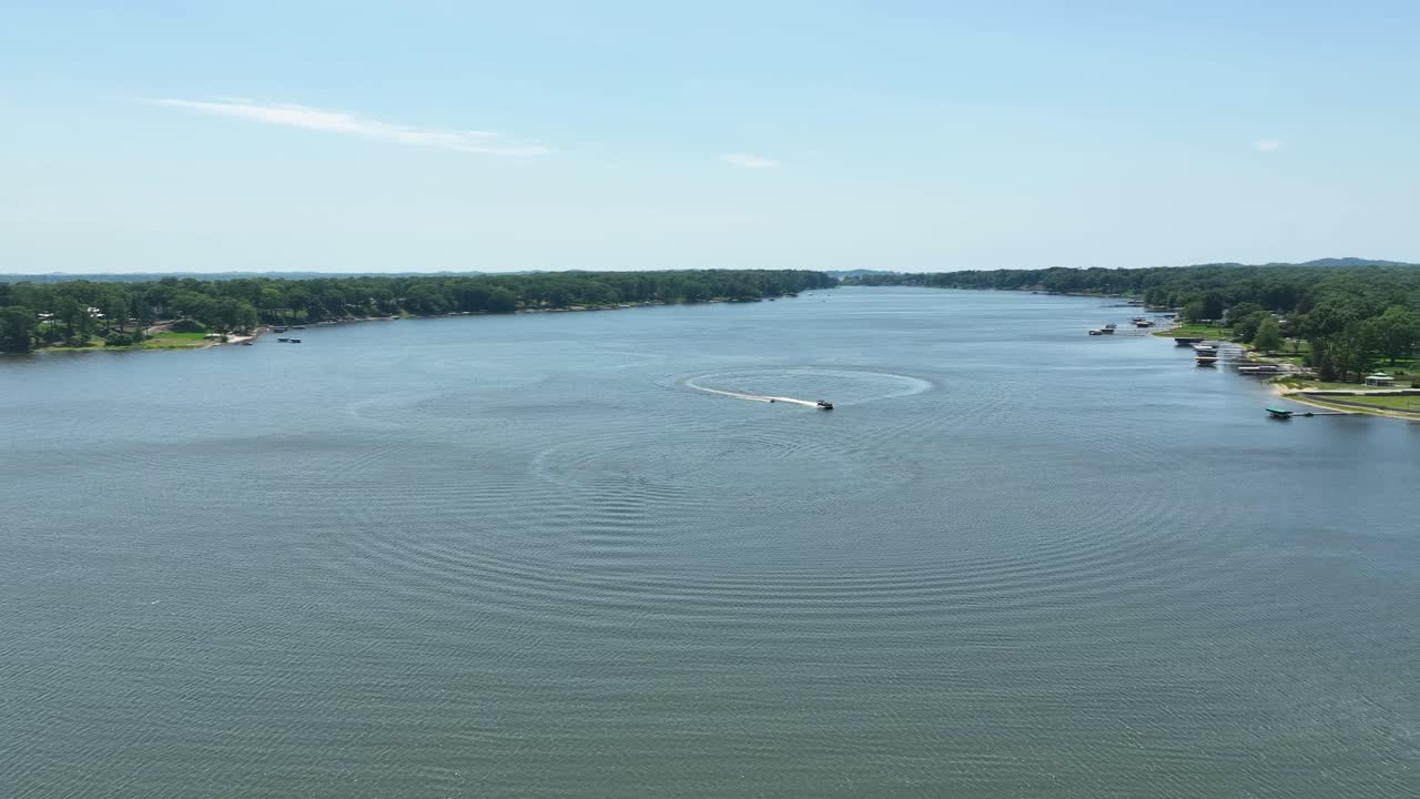 드론이 작은 개인 보트를 보여주기 위해 돌 때  ⁇  호수에 여름 날