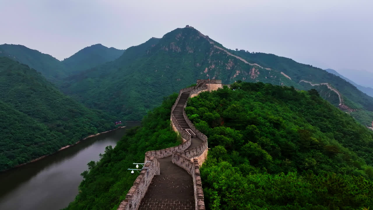 Drohne fliegt rückwärts entlang der Chinesischen Mauer an einem Sommertag in Peking.