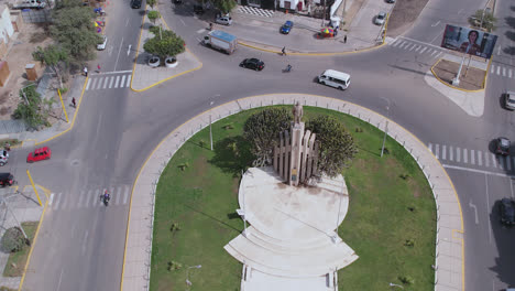 beautiful drone shot rotating over the famous "ovalo quiñones" oval on the highway of the city of chiclayo, peru while cars and people pass by during the day