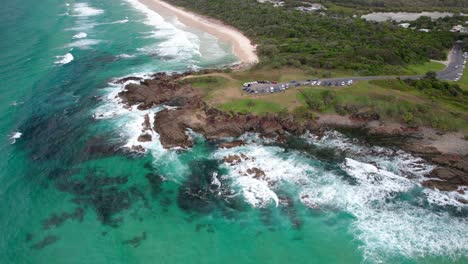waves crashing on rocky coastline - hastings point lookout in nsw, australia - drone shot