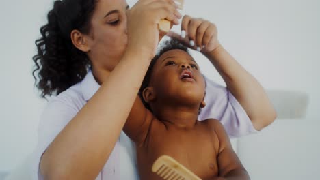 mother combing her baby's hair