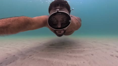 person swimming underwater with a snorkeling mask